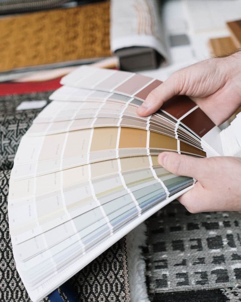 Hands holding a fanned-out selection of colour swatches