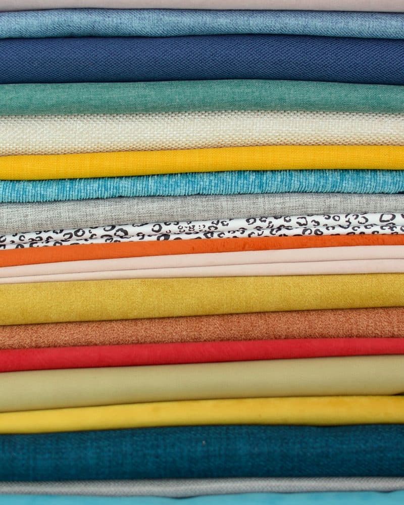 A stack of folded fabric in an array of colours
