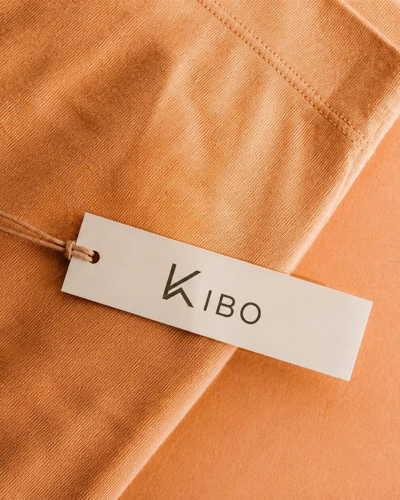 Close-up of folded orange fabric with a KIBO hangtag